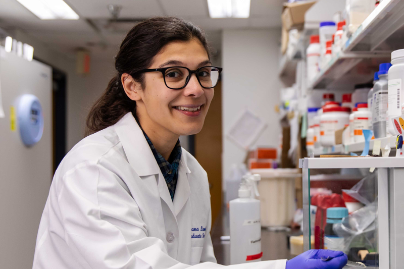 A student smiling in a lab